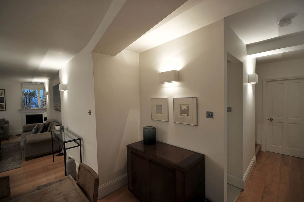 A hallway lit with up and down wall lights