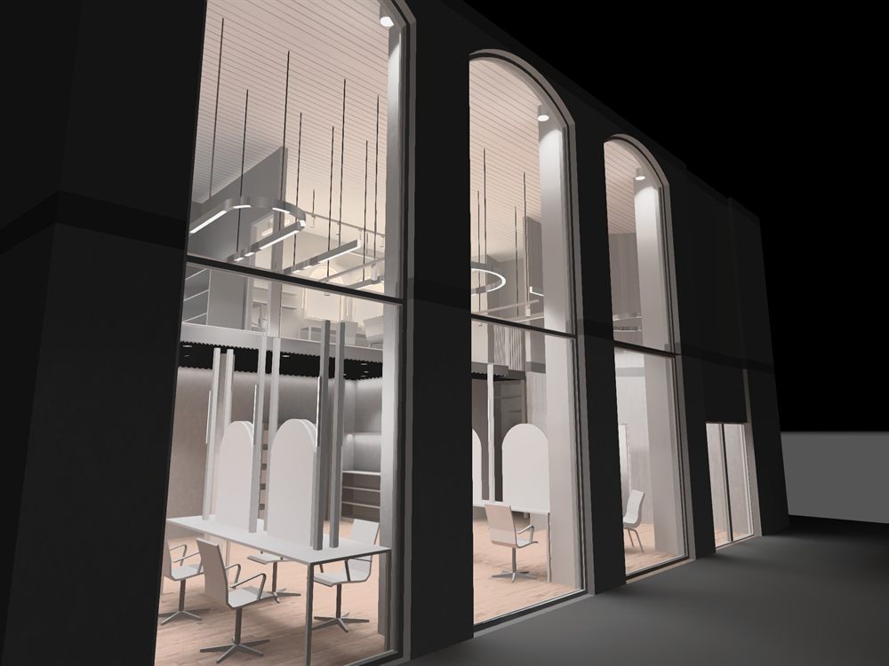 Night view of the salon shopfront with the lighting scheme visible through the arched windows