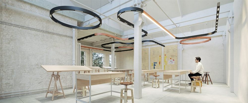 Serpent Plus serpentine runs and rings threading across a studio ceiling